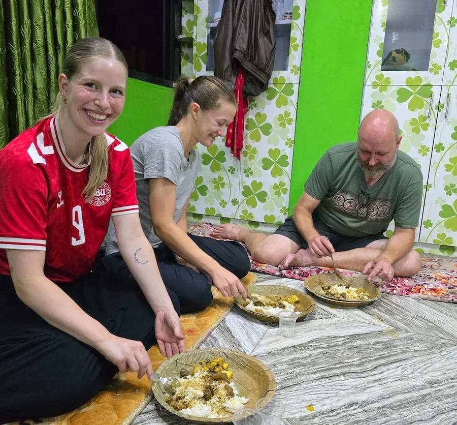 Volunteers sharing dal bhat with their Nepali host family in Kathmandu